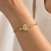 Medalha de São Bento dourada no bracelete