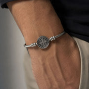 Bracelete dourado com o verso da Medalha de São Bento