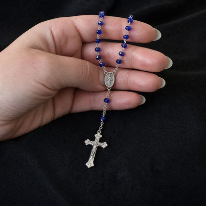 Escala dos cristais, medalha e crucifixo do Rosário Sacro Studio na mão